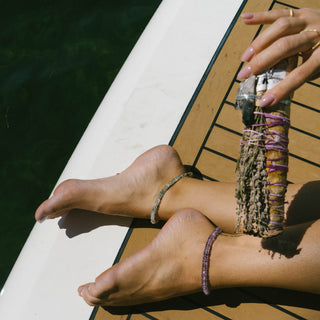 Raw amethyst anklet worn in spiritual setting, violet flame healing crystal jewelry for transformation