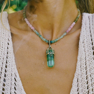 Close-up of raw aquamarine pendant detail, emotional clearing crystal jewelry with gold findings