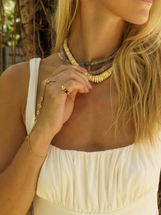 Woman wearing layered raw stone beaded necklaces from Sanamama's beaded collection featuring natural gemstones in earth tones