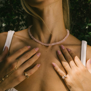 Woman wearing Sanamama raw rose quartz beaded necklace with hands on heart, unconditional love healing jewelry