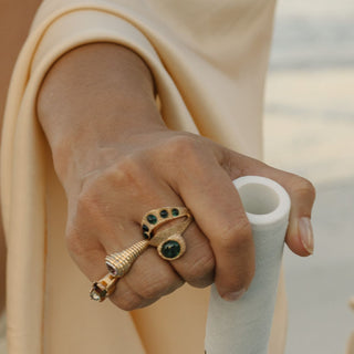 14k gold spiritual ring with green tourmaline, stacked with band, side angle on hand.